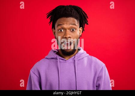 Foto Porträt Mann mit Dreadlocks starren in Sportswear isoliert lebendige rote Farbe Hintergrund erstaunt Stockfoto