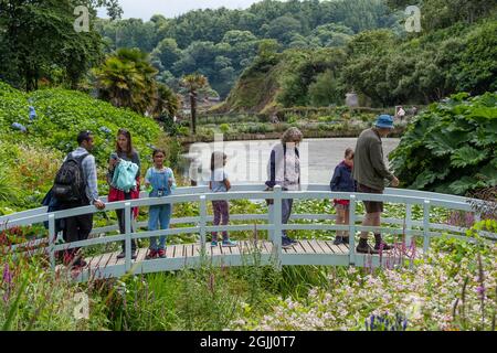 Besucher stehen auf der dekorativen hölzernen Mallard Bridge im spektakulären subtropischen Trebah Garden in Cornwall. Stockfoto