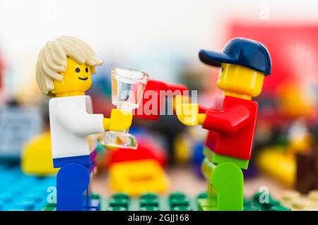 POZNAN, POLEN - 15. Feb 2019: Zwei Lego-Mann-Figuren halten Glas und Tasse und schauen sich bei einem Gespräch an. Stockfoto