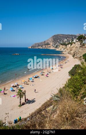 Calpe, Spanien - 19. Juli 2021: Sandstrand mit Touristen für Freizeit, Schwimmen und Sonnenbaden entlang der Küste Stockfoto