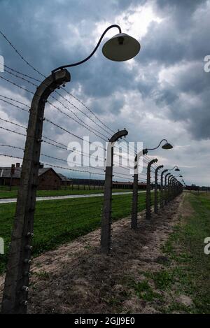 Auschwitz, Polen - 30. August 2018: Elektrifizierter Zaun des Konzentrationslagers Auschwitz-Birkenau bei Sonnenuntergang, einem von den Nazis betriebenen Vernichtungslager Stockfoto