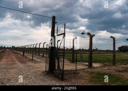 Auschwitz, Polen - 30. August 2018: Elektrifizierter Zaun des Konzentrationslagers Auschwitz-Birkenau bei Sonnenuntergang, einem von den Nazis betriebenen Vernichtungslager Stockfoto