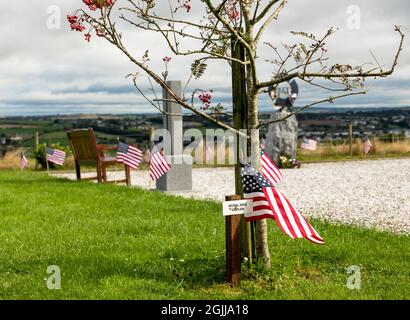 Ringfinnan, Kinsale, Cork, Irland. 10. September 2021.eine amerikanische Flagge steht neben einem Baum, der in Erinnerung an den Kaplan Michael Judge gepflanzt wurde, der sein Leben während des Angriffs von 9/11 opferte. Insgesamt wurden 343 Bäume gepflanzt, um an alle Feuerwehrmänner zu erinnern, die an diesem Tag im Garden of Remembrance in Ringfinnan, Kinsale, Co. Cork, Irland, starben - Bild; David Creedon / Alamy Live News Stockfoto