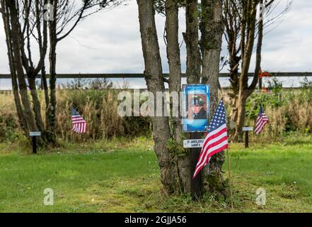 Ringfinnan, Kinsale, Cork, Irland. 10. September 2021.eine amerikanische Flagge steht neben einem Baum, der zum Gedenken an den Feuerwehrmann James Coyle gepflanzt wurde, der sein Leben opferte, um andere während des Angriffs von 9/11 zu retten. Insgesamt wurden 343 Bäume gepflanzt, um an alle Feuerwehrmänner zu erinnern, die an diesem Tag im Garden of Remembrance in Ringfinnan, Kinsale, Co. Cork, Irland, starben - Bild; David Creedon / Alamy Live News Stockfoto