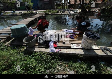 Bekasi, Indonesien. September 2021. Tägliches Leben der Bewohner in einem trüben Fluss im Cilemahabang Fluss, Sukaraya Dorf, Bekasi Regency, West Java. Die Bewohner rund um den Fluss sind gezwungen, das trübe Flusswasser für ihren täglichen Bedarf und als Hauptwasserquelle wie zum Baden, Zähneputzen, Waschen von Kleidung und Waschen von Reis zum Kochen zu nutzen. (Foto von Kuncoro Widyo Rumpoko/Pacific Press) Quelle: Pacific Press Media Production Corp./Alamy Live News Stockfoto