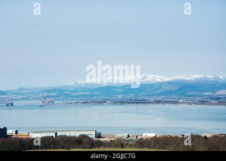 Der imposante schneebedeckte Ben Wyvis thront über der kleinen Stadt Invergordon, die sich am Ende des inneren Cromarty Firth in den schottischen Highlands befindet Stockfoto