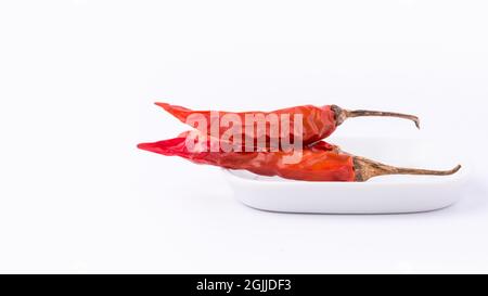 Getrocknete rote Chili oder Cayennepfeffer auf einem weißen Tablett, Nahaufnahme von heißem Gewürz isoliert auf weißem Hintergrund Stockfoto