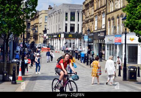 HALIFAX. WEST YORKSHIRE. ENGLAND. 05-29-21. Cornmarket im Stadtzentrum. Einkäufer und Radfahrer. Stockfoto