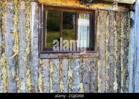 Nahaufnahme eines Fensters in der Wand einer Blockhütte. Stockfoto