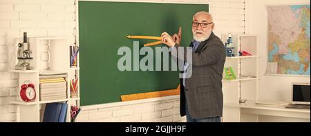 Wiederholen Sie nach mir. In Richtung Wissen. Studieren Sie Mathematik, um gute Ergebnisse zu erhalten. Senior man Lehrer verwenden Kompass-Werkzeug. Bärtiger Tutor Mann zeichnen mit Kompass auf Stockfoto