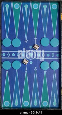 Ein farbenfrohes Brett zum Spielen von Backgammon, mit geometrischen Mustern, Steinen und Würfeln Stockfoto