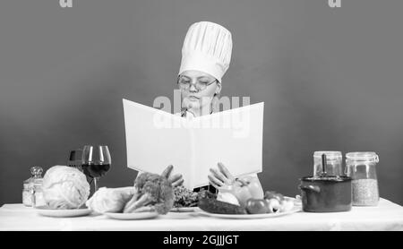 Konzept für das Kochen zu Hause. Chefin auf der Suche nach Rezepten. Kulinarische Anleitungen im Internet. Restaurant Menü Design. Meisterkurs für kulinarische Kunst Stockfoto