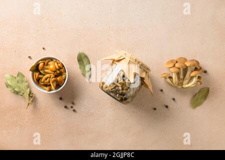 Eingelegte Honigpilze in einer Schüssel mit Lorbeerblatt und Gewürzen serviert. Blick von oben. Stockfoto