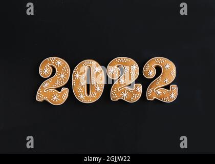 Lebkuchen Cookies in Form von Zahlen, Lebkuchen Neujahr 2022 auf schwarzem Hintergrund. Draufsicht. Flach liegend Stockfoto