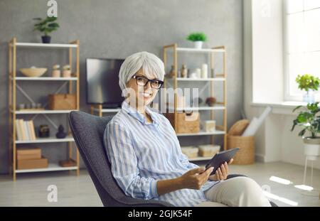 Porträt einer glücklichen Frau mittleren Alters verwenden Tablet-Gerät Stockfoto