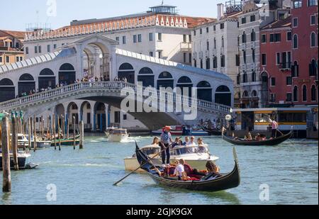 Eine Gondel auf dem Canal Grande in Venedig, die bei San Marco in die Lagune führt. Touristen genießen die wunderschöne Architektur Venedigs von einer Gondel aus. Stockfoto