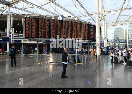 Passagiere von Manchester Piccadilly sehen sich die Informationstafeln an. Stockfoto