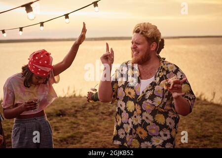 Junge Leute, die Spaß haben und gemeinsam am Strand tanzen Stockfoto