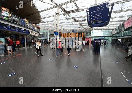 Passagiere von Manchester Piccadilly sehen sich die Informationstafeln an. Stockfoto