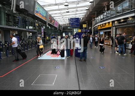 Passagiere von Manchester Piccadilly sehen sich die Informationstafeln an. Stockfoto