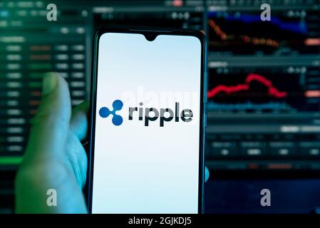 Das Ripple Kryptowährung-Logo ist auf dem Display eines Mobiltelefons mit einem Laptop mit einem Aktienchart im Hintergrund in Barcelona, Spanien, am September zu sehen Stockfoto