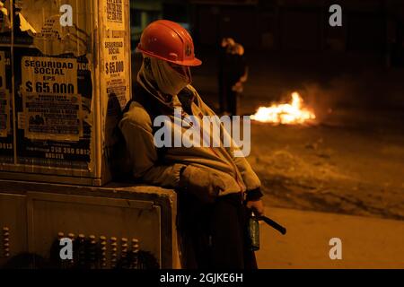 Bogota, Kolumbien. September 2021. Ein Protestler macht während der Demonstration eine Pause. Der Streik ist eine Reaktion auf den Jahrestag, an dem die Polizei vor einem Jahr in Bogota, Kolumbien, in einer Nacht 13 Menschen getötet hat. Der Protest ist Teil eines laufenden nationalen Streiks, der am 28. April in Kolumbien als Reaktion auf Steuerreformen begann, die die Ärmsten des Landes zum Ziel hätten. Kredit: SOPA Images Limited/Alamy Live Nachrichten Stockfoto