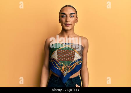 Hispanic Mann trägt Make-up und lange Haare tragen Womans Top mit einem glücklichen und kühlen Lächeln im Gesicht. Glückliche Person. Stockfoto