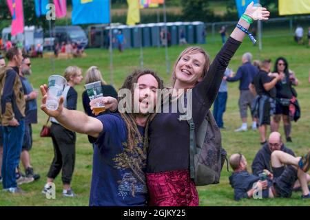 Vicarage Farm, Winchester Hampshire, Großbritannien. September 2021. Mann und Frau posieren für die Kamera beim Musikhören im Mucky Weekender, Hampshire Credit: Dawn Fletcher-Park/Alamy Live News Stockfoto