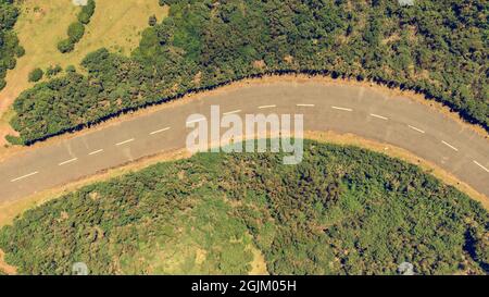 Drop-down-Ansicht einer Straßenkurve, die durch die Landschaft führt. Stockfoto