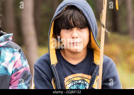 Halblanges Porträt eines weißen kaukasischen Jungen mit braunem Haar, das ein Kapuzenpullover trägt. Stockfoto