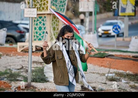 Palästina. September 2021. Arabisch-israelische Demonstranten schwenkten palästinensische Flaggen und Löffel, die diese Woche zur Flucht der sechs palästinensischen Gefangenen aus dem Gilboa Gefängnis verwendet wurden. Der Protest in Umm al-Fahm verurteilte heute die nach dem Gefängnisbruch von den israelischen Gefängnisdiensten ergriffenen Strafmaßnahmen und die Maßnahmen gegen gewalttätige Verhöre. Nach einigen Statistiken wurde einer von fünf Palästinensern zu Lebzeiten in israelischen Gefängnissen inhaftiert. Umm al-Fahm, Israel, am 11. September 2021. (Foto von Matan Golan/Alamy Live News) Quelle: Matan Golan/Alamy Live News Stockfoto