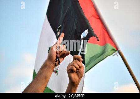 Palästina. September 2021. Arabisch-israelische Demonstranten schwenkten palästinensische Flaggen und Löffel, die diese Woche zur Flucht der sechs palästinensischen Gefangenen aus dem Gilboa Gefängnis verwendet wurden. Der Protest in Umm al-Fahm verurteilte heute die nach dem Gefängnisbruch von den israelischen Gefängnisdiensten ergriffenen Strafmaßnahmen und die Maßnahmen gegen gewalttätige Verhöre. Nach einigen Statistiken wurde einer von fünf Palästinensern zu Lebzeiten in israelischen Gefängnissen inhaftiert. Umm al-Fahm, Israel, am 11. September 2021. (Foto von Matan Golan/Alamy Live News) Quelle: Matan Golan/Alamy Live News Stockfoto