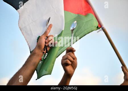 Palästina. September 2021. Arabisch-israelische Demonstranten schwenkten palästinensische Flaggen und Löffel, die diese Woche zur Flucht der sechs palästinensischen Gefangenen aus dem Gilboa Gefängnis verwendet wurden. Der Protest in Umm al-Fahm verurteilte heute die nach dem Gefängnisbruch von den israelischen Gefängnisdiensten ergriffenen Strafmaßnahmen und die Maßnahmen gegen gewalttätige Verhöre. Nach einigen Statistiken wurde einer von fünf Palästinensern zu Lebzeiten in israelischen Gefängnissen inhaftiert. Umm al-Fahm, Israel, am 11. September 2021. (Foto von Matan Golan/Alamy Live News) Quelle: Matan Golan/Alamy Live News Stockfoto