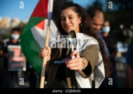 Palästina. September 2021. Arabisch-israelische Demonstranten schwenkten palästinensische Flaggen und Löffel, die diese Woche zur Flucht der sechs palästinensischen Gefangenen aus dem Gilboa Gefängnis verwendet wurden. Der Protest in Umm al-Fahm verurteilte heute die nach dem Gefängnisbruch von den israelischen Gefängnisdiensten ergriffenen Strafmaßnahmen und die Maßnahmen gegen gewalttätige Verhöre. Nach einigen Statistiken wurde einer von fünf Palästinensern zu Lebzeiten in israelischen Gefängnissen inhaftiert. Umm al-Fahm, Israel, am 11. September 2021. (Foto von Matan Golan/Alamy Live News) Quelle: Matan Golan/Alamy Live News Stockfoto