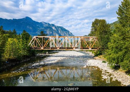 Brücke über die North Fork des Skykomish River in Index Washington unter teilweise bewölktem Himmel. Die Brücke war Stockfoto