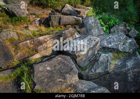 Große eingestürzte Blöcke oder Felsbrocken aus dem Sandstein des Loxley Edge Rock bei Sonnenschein am späten Nachmittag auf dem Loxley Edge in der Nähe von Sheffield. Stockfoto