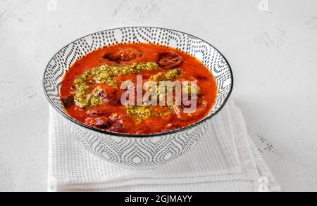 Schüssel mit Nierenbohne und Chorizo-Eintopf, garniert mit Pesto Stockfoto