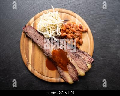 BBQ Brisket im Texas-Stil mit Pinto-Bohnen, Krautsalat und roter Sauce von oben Stockfoto