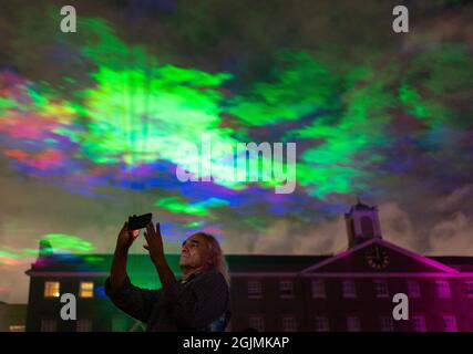 Im Rahmen des Greenwich and Docklands Intentional Festival in der Royal Artillery Barracks in Woolwich sehen die Menschen „Borealis“, eine Laserlicht-Kunstinstallation von Dan Acher, die die Nordlichter nachbildet. Bilddatum: Freitag, 10. September 2021. Stockfoto