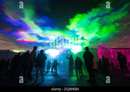 Im Rahmen des Greenwich and Docklands Intentional Festival in der Royal Artillery Barracks in Woolwich sehen die Menschen „Borealis“, eine Laserlicht-Kunstinstallation von Dan Acher, die die Nordlichter nachbildet. Bilddatum: Freitag, 10. September 2021. Stockfoto