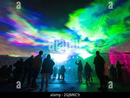 Im Rahmen des Greenwich and Docklands Intentional Festival in der Royal Artillery Barracks in Woolwich sehen die Menschen „Borealis“, eine Laserlicht-Kunstinstallation von Dan Acher, die die Nordlichter nachbildet. Bilddatum: Freitag, 10. September 2021. Stockfoto