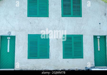 Fassade eines Hauses mit geschlossenen grünen hölzernen Fensterläden Fenster und Türen Stockfoto