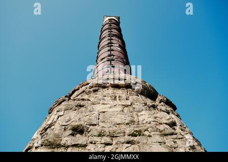 Istanbul-Säule von Konstantin (cemberlitas) Foto von der Unterseite der antiken römischen Säule mit hellblauem Himmel und fliegender Möwe aufgenommen. Stockfoto