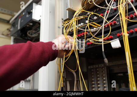 Der Techniker, der Glasfaser an ODF am Telekommunikationsstandort anverbindet Stockfoto