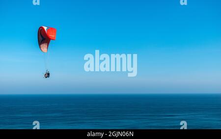 Gleitschirme fliegen über den Ozean Stockfoto