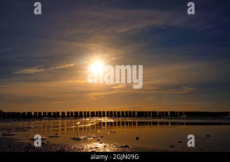 Sonnenuntergang in Zingst am Meer. Rot-orange Sonne untergeht am Horizont. Möwen kreisen am Himmel. Eine schöne Lichtatmosphäre, die zum Träumen einlädt. T Stockfoto