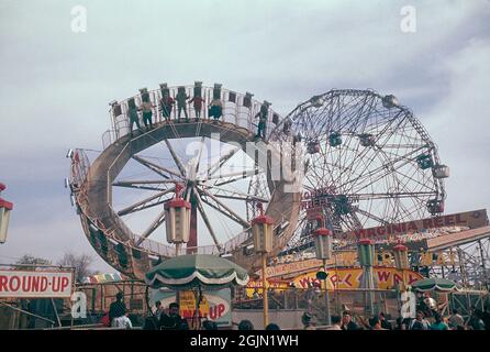 USA 1959. Wonder Wheel auf Coney Island New York. Ein Überblick über ein Gebiet mit Vergnügungsfahrten und Attraktionen. Im Hintergrund ist eine Achterbahn zu sehen. Kodachrome Dia Original. Credit Roland Palm Ref. 6-2-2 Stockfoto