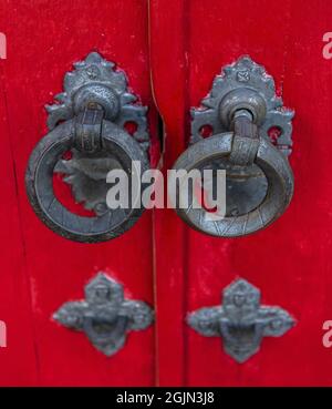 Nahaufnahme der Vintage-Metallgriffe an der roten Tür Stockfoto