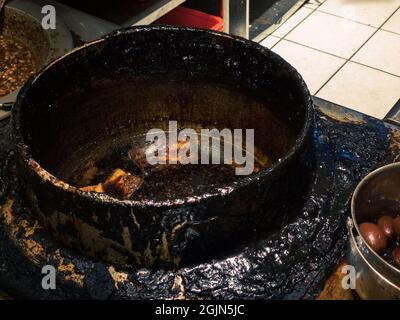 Geschmorter Schweinebauch auf schmutzigem Schmortopf. Bereiten Sie sich auf den Koch vor, kochen Sie eine Scheibe geschmortes Fleischschwein mit brauner Sauce im chinesischen Speisestil. Traditionelles Taiwane Stockfoto