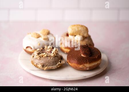 Mehrere Arten von Donuts auf einer Marmorplatte, Essen Stockfoto